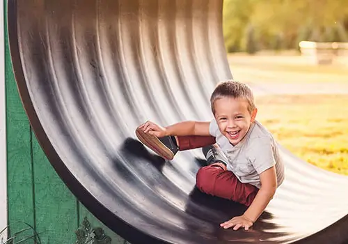 A young boy poses during golden hour during an outdoor photoshoot at the farm.